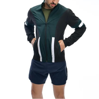 Man wearing a green and black tracksuit with white stripes on a white background